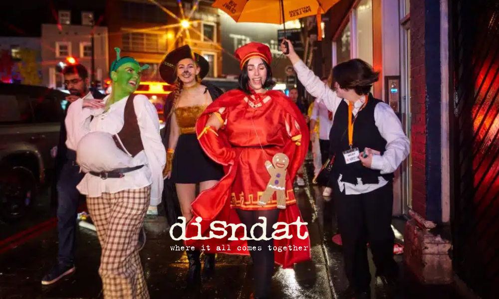 Costumed friends walking under umbrella on rainy city street
