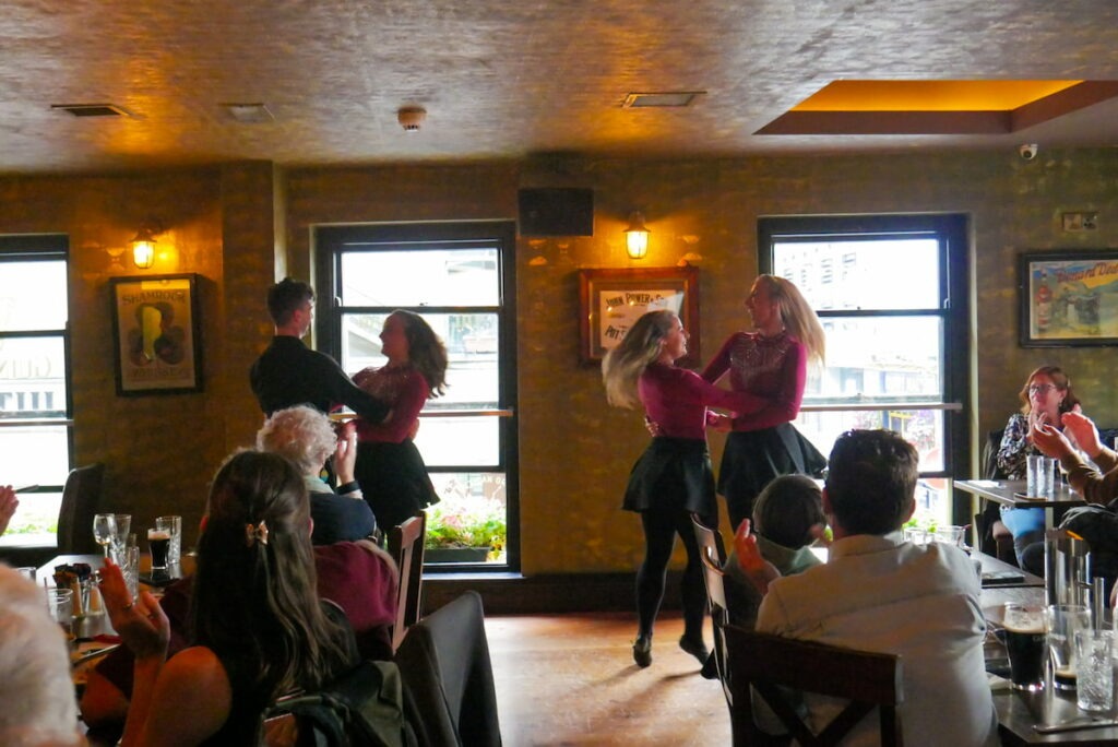 Irish dancers performing in a cosy pub