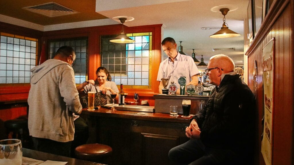 Customers and bartender in traditional pub interior