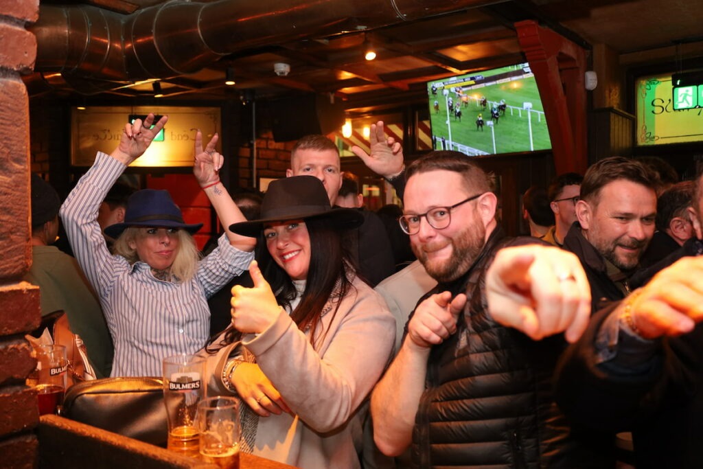 Friends enjoying drinks and pointing in lively pub