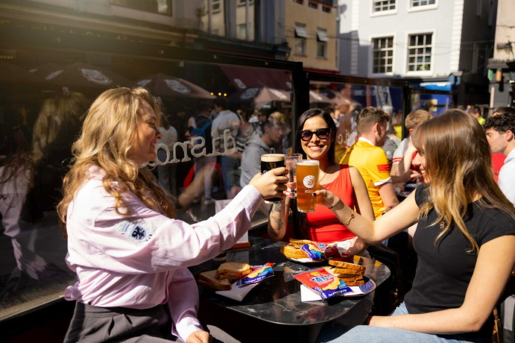 Friends toasting drinks at outdoor café table